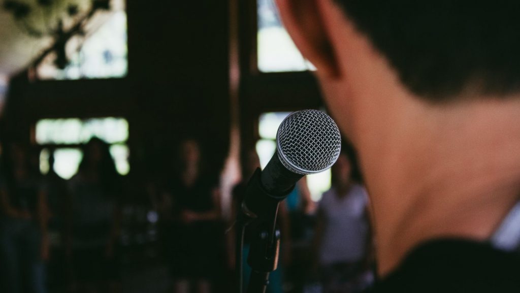 a person giving a speech using a microphone.