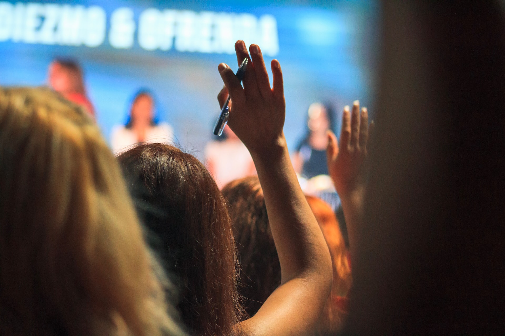 people raising their hands during an event