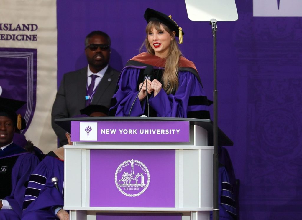 Taylor Swift speaking behind a Podium Pros podium at NYU's Graduation Ceremony.